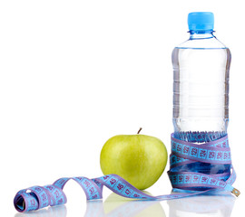 Bottle of water, apple and measuring tape isolated on white