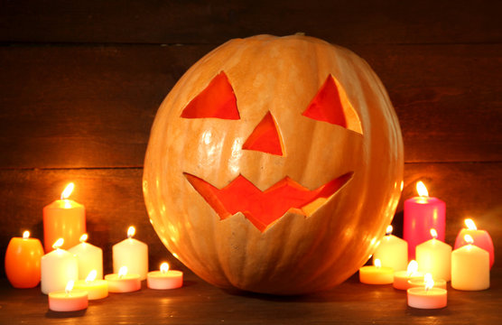 halloween pumpkin and candles, on wooden background