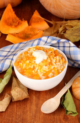 Useful pumpkin porridge in white plate on wooden table close-up