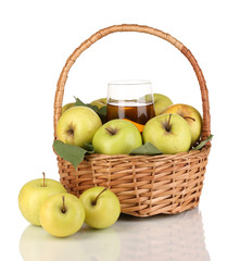 Useful apple juice with apples around in basket isolated