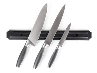 Set of knives on magnetic holder isolated on white