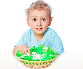 boy sitting at a table covered with a basket of eggs