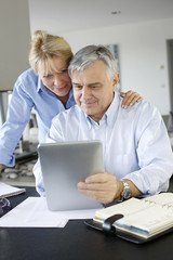 Fototapeta premium Senior couple looking at bank account on digital tablet