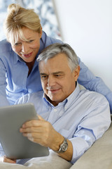 Modern senior couple websurfing on tablet
