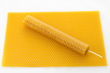 Candle made of beeswax on honeycomb - background