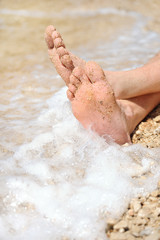 Fototapeta premium Relaxation on beach, detail of male feet