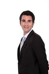 Happy businessman with his hands behind his back