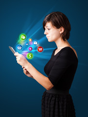 Young woman looking at modern tablet with abstract lights and va