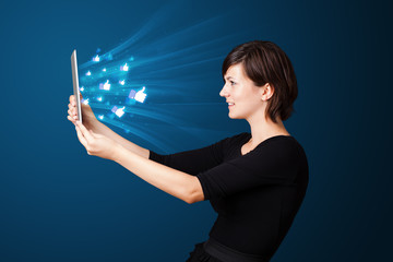 Young woman looking at modern tablet with abstract lights and so