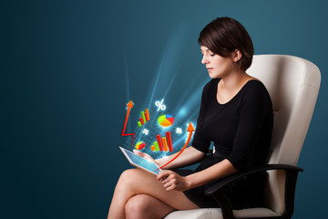 Young woman looking at modern tablet with abstract lights and va