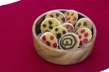 Small cakes on a wooden bowl over red towel
