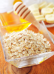 Raw oat flaks in the glass bowl