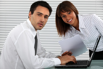Obraz premium businessman and female colleague working on laptop