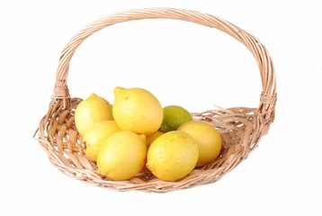 organic lemons in a straw basket, isolated on white