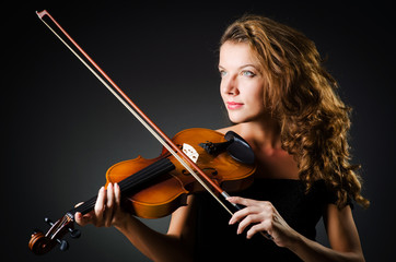 Fototapeta premium Woman with violin in dark room