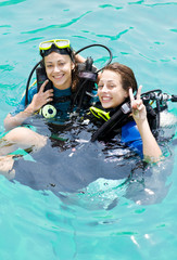Portrait of two attractive friends going scuba diving