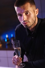 Evening portrait of young man with champagne flute