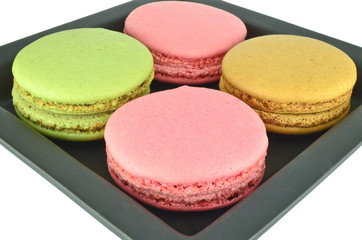 Colorful macaroons in the black plate