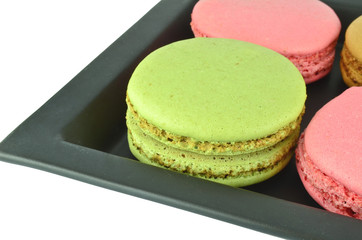 Colorful macaroons in the black plate