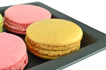 Colorful macaroons in the black plate