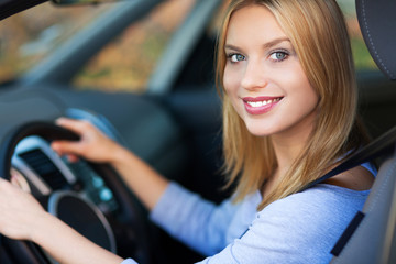 Fototapeta na wymiar Uśmiechnięta kobieta siedzi w samochodzie