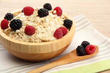 tasty oatmeal with berries, on wooden table
