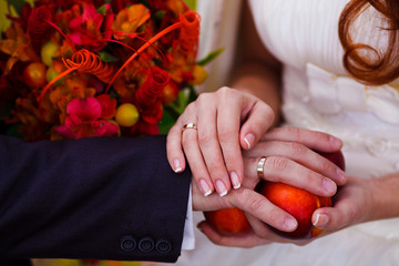 newlyweds hands rings on wedding bouquet