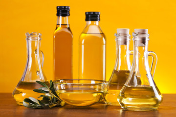 Olive oil and olives set on yellow background