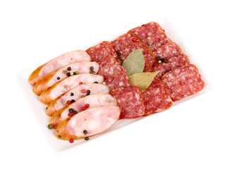 Tasty sliced sausage on plate isolated on white