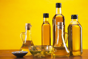 Olive oil and olives set on yellow background