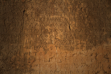 Fototapeta na wymiar Grecki napis wykuty w kamieniu w starożytnych ruinach