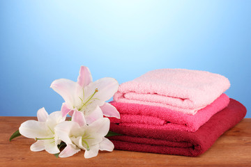 stack of towels with pink lily on blue background.