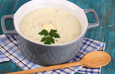 Mashed potatoes in saucepan on blue wooden table
