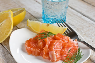 Salmon on plate with lemon on wooden background