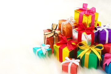 Pile of gifts on white fake fur background. (horizontal)