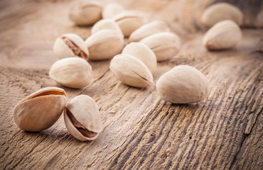 Pistachio nuts on very old wooden table, closeup