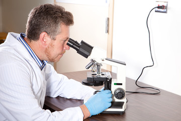 Naklejka na ściany i meble Lab scientist looks into microscope