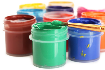 jars with multicolored gouache on white background close-up