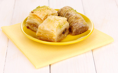 Sweet baklava on plate on wooden background