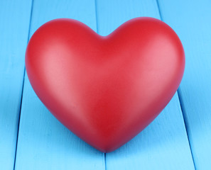 Decorative red heart close-up on blue wooden table