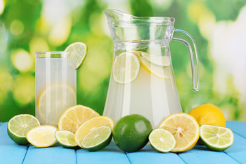 Citrus lemonade in pitcher and glass of citrus around