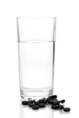 glass of water and activated carbon isolated on white