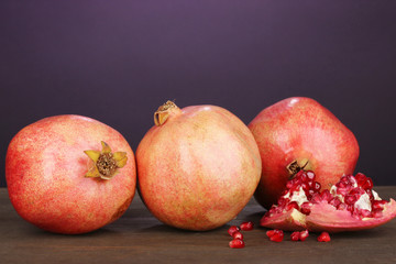 Ripe pomegranates on purple background