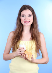 Beautiful woman with milk and cheese on blue background