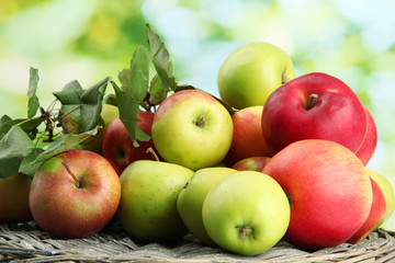 juicy apples with leaves, on green background