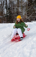 Girl rides sledge down hill