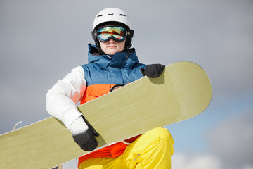 female snowboarder against sun and blue sky