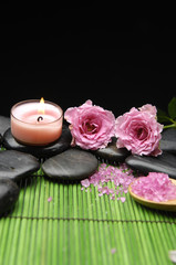 Fototapeta na wymiar Pink rose and zen stones with herbal salt in spoon with candle