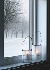 Obraz premium Cozy lanterns and winter landscape seen through the window