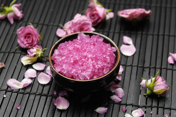 Obraz na płótnie Canvas Pink herbal salt with rose petals and stones on mat